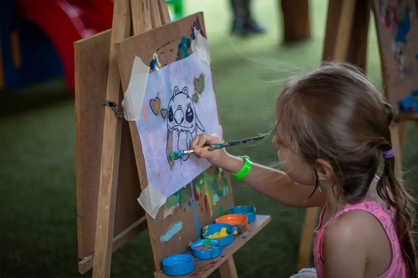 Niña pintando en un caballete del Mini Club