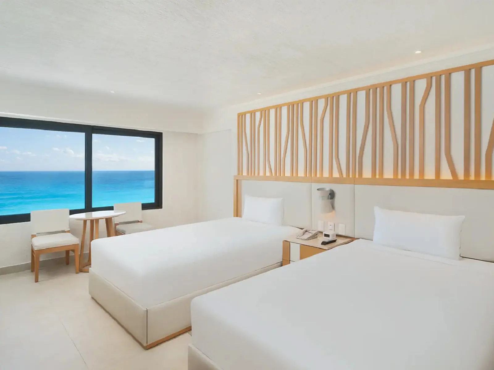 Habitación con dos camas y ventanal al Mar Caribe